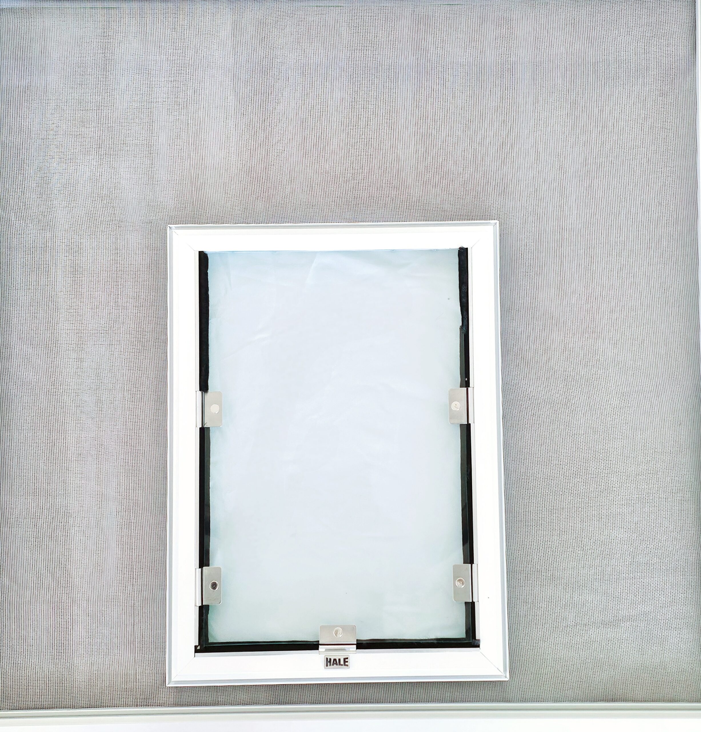 Complete universal screen dog door installed in a screen door frame